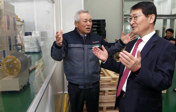 신한은행 위성호 은행장(오른쪽)이 29일 시행한 경기 공단지역 현장경영에서 안산시 소재 일신화학공업을 방문해 정철수 사장(왼쪽)과 생산시설을 둘러보며 의견을 나눴다. (사진 = 신한은행)