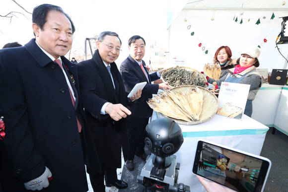 황창규 KT 회장(가운데), 이희범 평창동계올림픽 위원장(왼쪽), 심재국 평창군수(오른쪽)가 의야지마을 꽃밭양지카페에서 5G AR 마켓 서비스를 체험하고 있다. (사진 = KT)